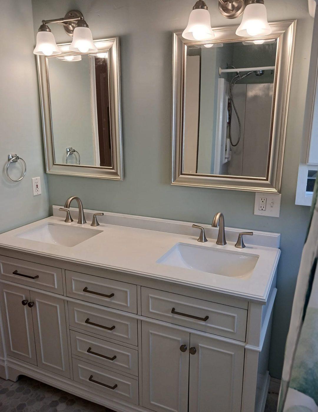 Finished bathroom with a double vanity, two framed mirrors and new taps