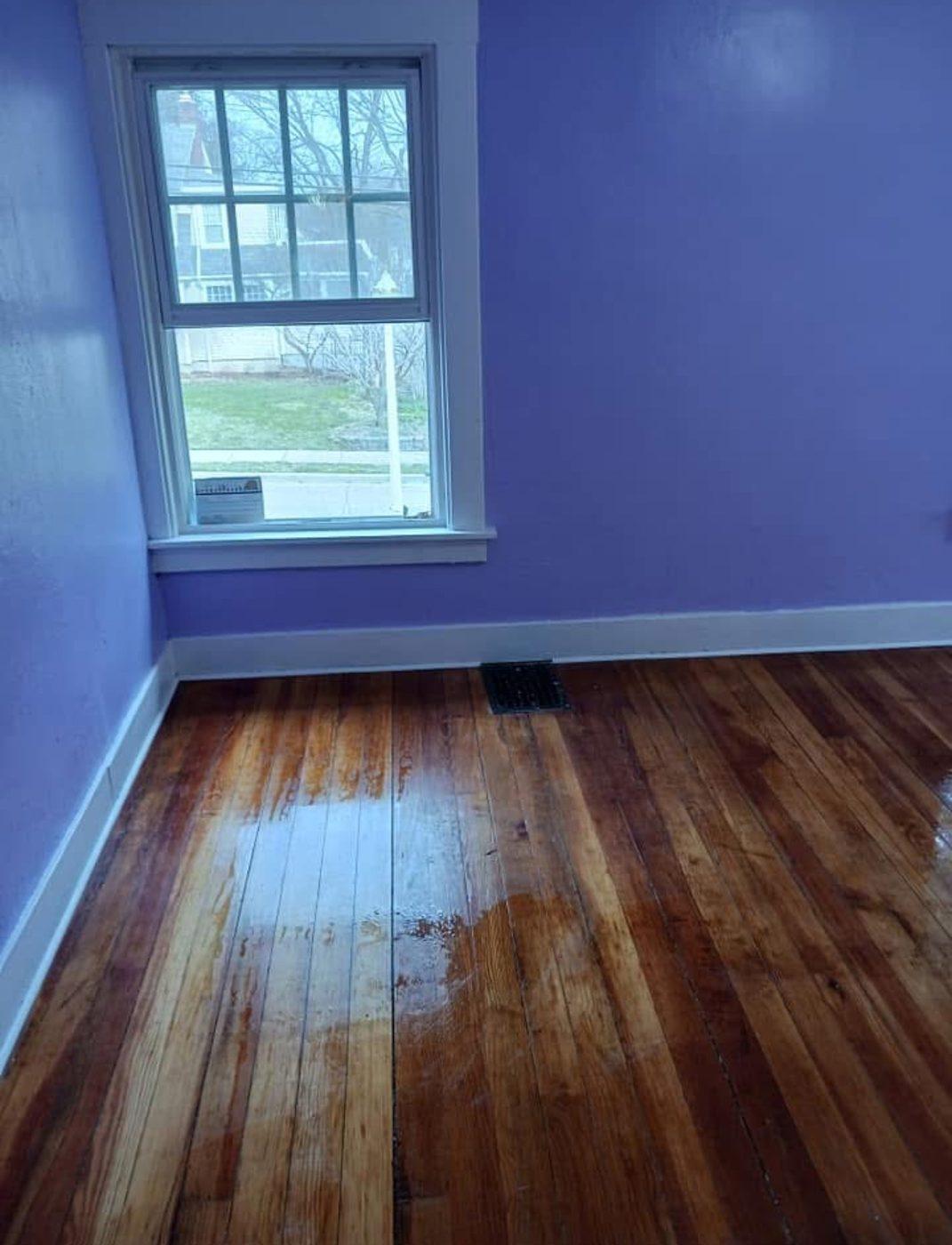 Refinished hardwood floor in a freshly painted room